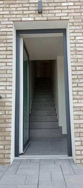 Entrance door with brick cladding and staircase to a 3-room apartment in Diakovce.
