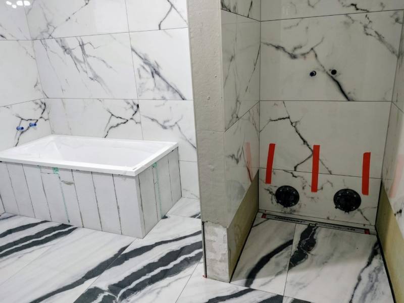 A bathroom in a family house with marble tiles and a bathtub, sophisticated design.