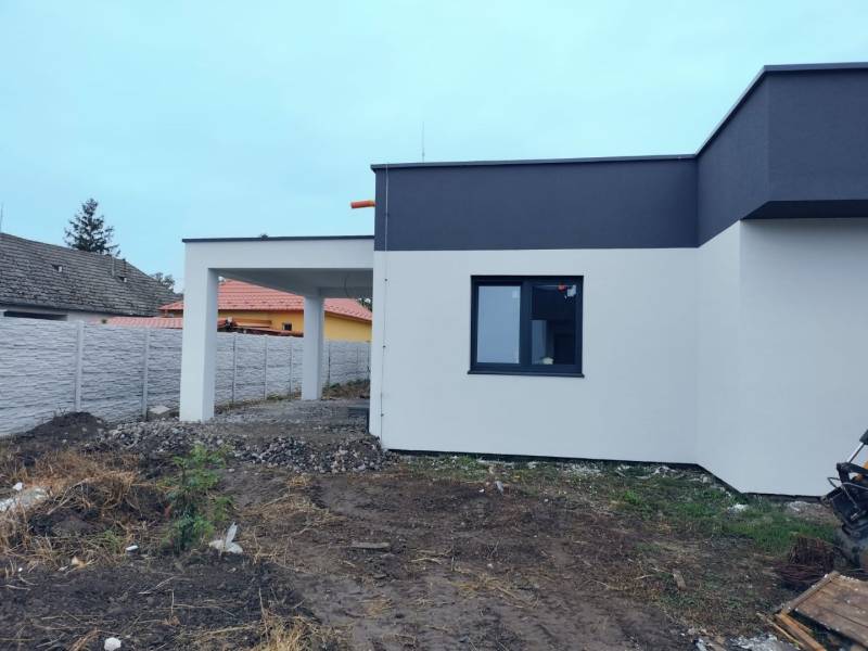 A family house in Žihárec with a modern facade and an adjacent pergola in the yard.