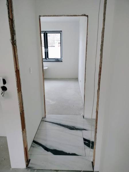 Interior renovation of a family house with white walls and marble flooring.