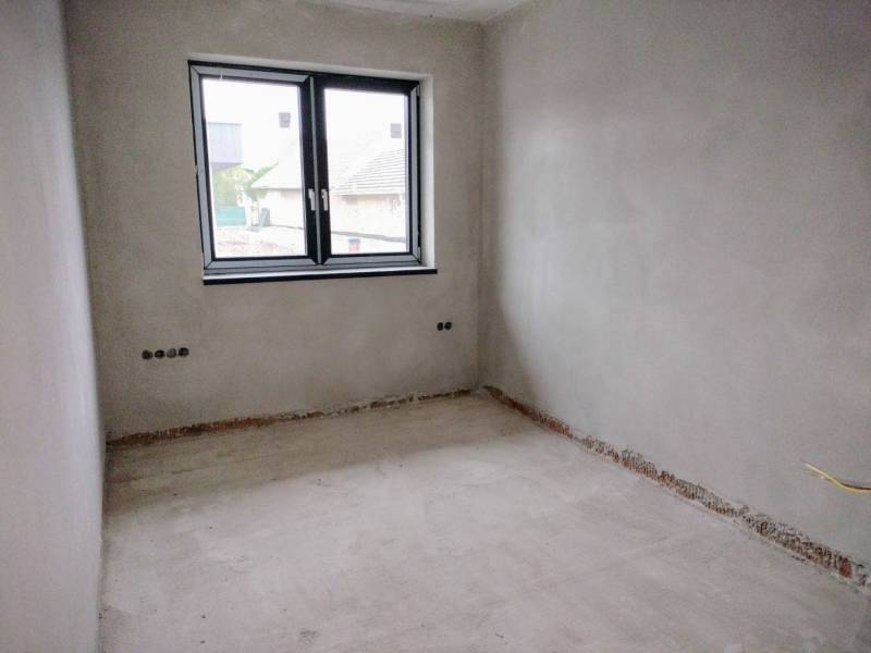 A place in a family house with plastered walls and a double window, without floor covering.