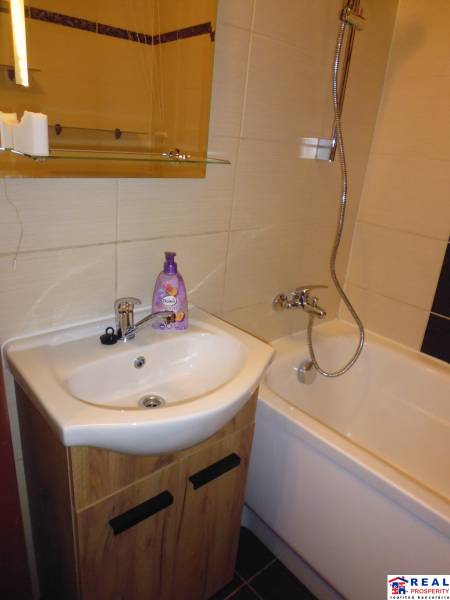 A bathroom with a bathtub and a sink in a two-room apartment.