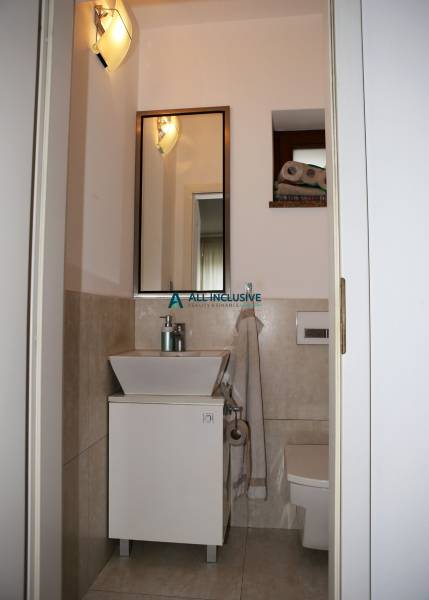 Bathroom with beige walls in a family house, with a sink and a mirror.