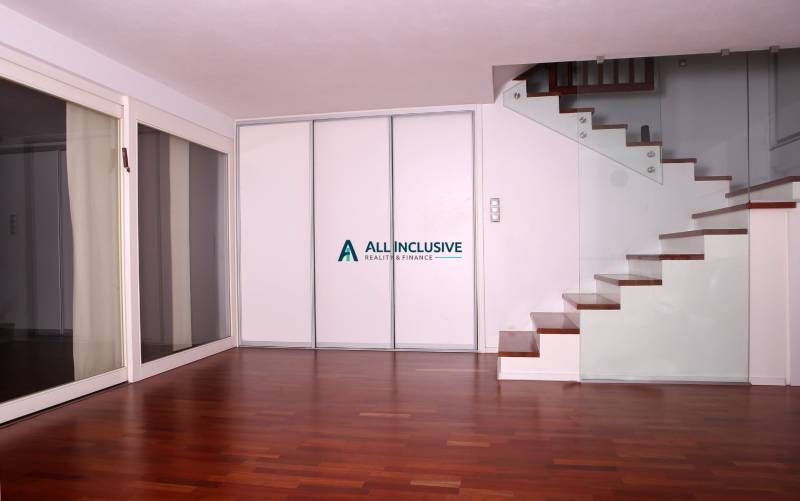 Interior of a family house with a wooden decor floor and a staircase with glass railing.