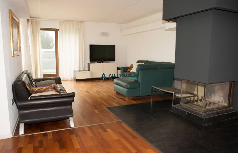Living room with a fireplace, television, and wood-patterned flooring in a family house.