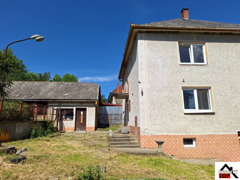 A family house in Šíd with an adjacent garden and an annex, under the blue sky.