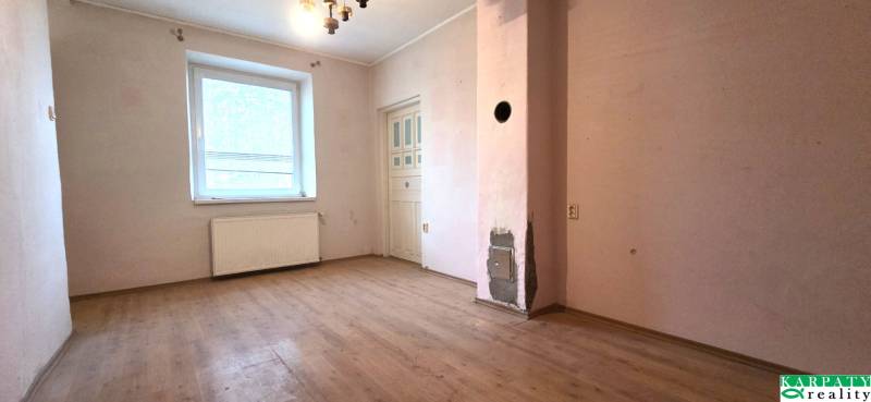 A room in a family house with a wooden decor floor and a window, for renovation.