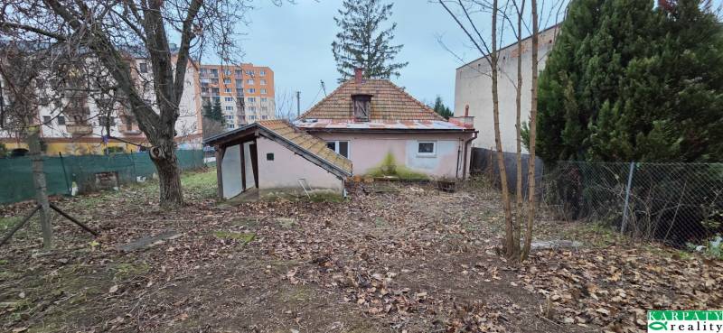 A family house on 29th August Street in Levice, surrounded by bare trees and apartment buildings.