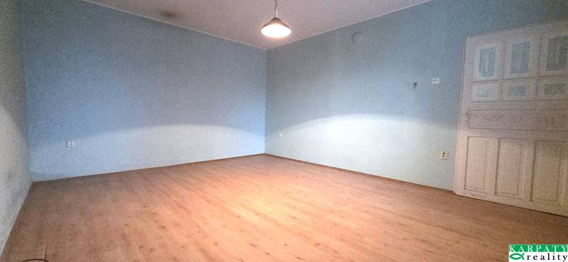 A room in a family house with a wooden decor floor and blue walls.