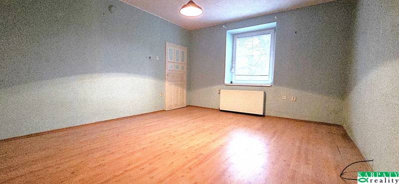 A room in a family house with a wooden decor floor and blue walls.