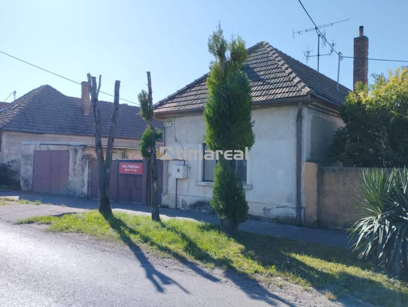 A family house in Reca with a wooden gate and a stone fence.