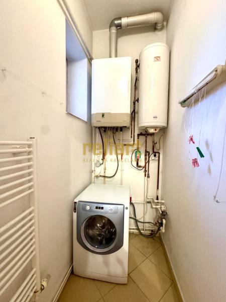 Laundry room of a 4-room apartment with a boiler, water heater, and washing machine.