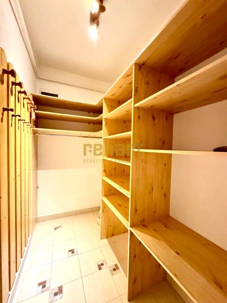 Storage space in a 4-room apartment with shelves and hanging rods.