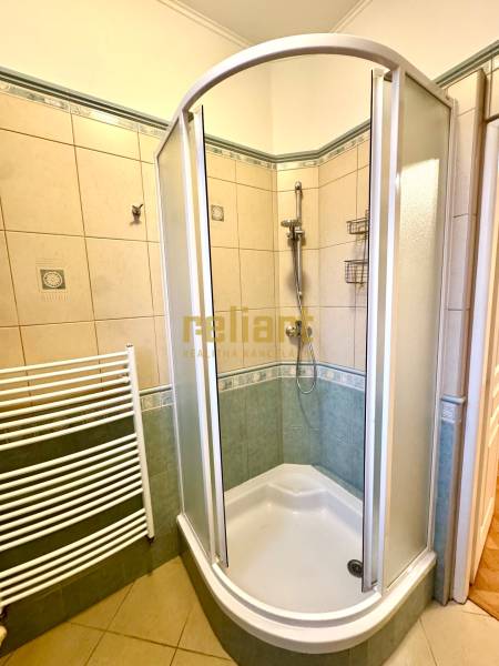 A bathroom with a shower and tiles in a 4-room apartment.