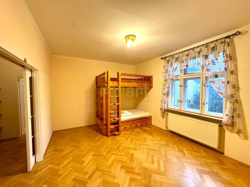 A bedroom in a 4-room apartment with a bunk bed and a floor with a wooden decor.