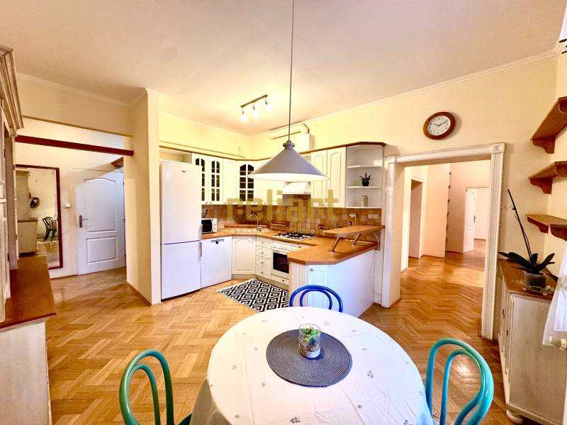 A kitchen in a 4-room apartment with a wooden decor floor and a dining table.
