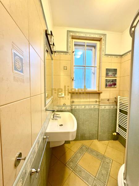 Bathroom with tiles, shower, and sink in a 4-room apartment.