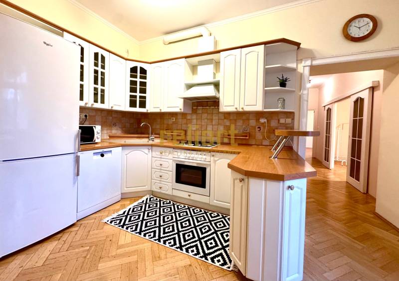 A kitchen in a 4-room apartment with white cabinets and a wood-patterned floor.