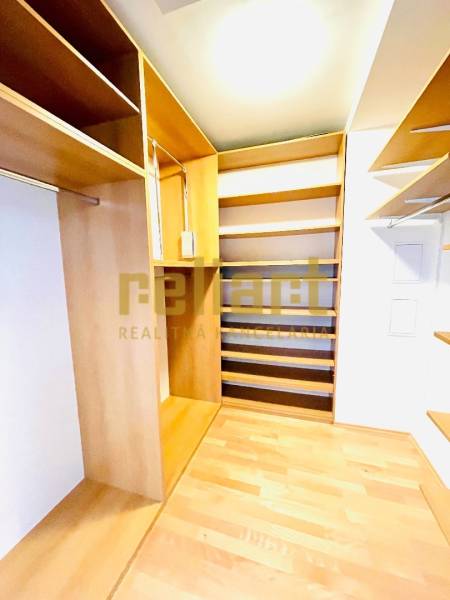 A wardrobe with shelves and a floor with a wood decor in a 4-room apartment.