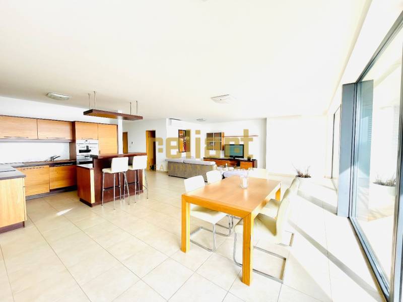 A bright kitchen with a dining table and large windows in a 4-room apartment.