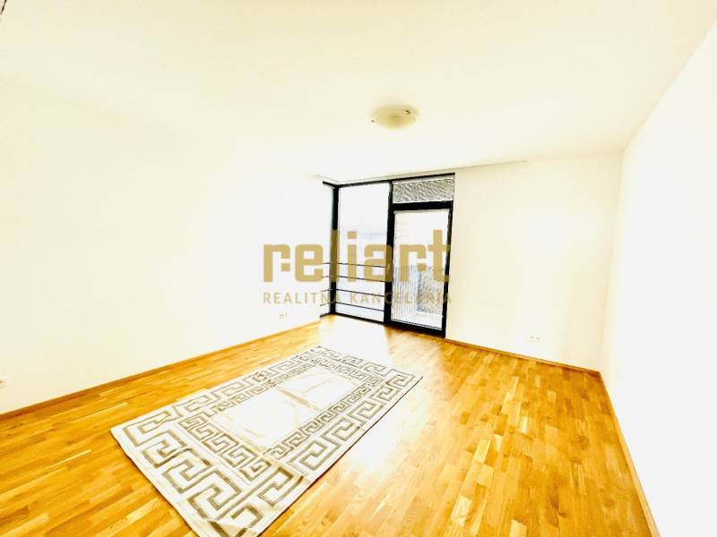 A room with a wooden decor floor and a carpet in a 4-room apartment.