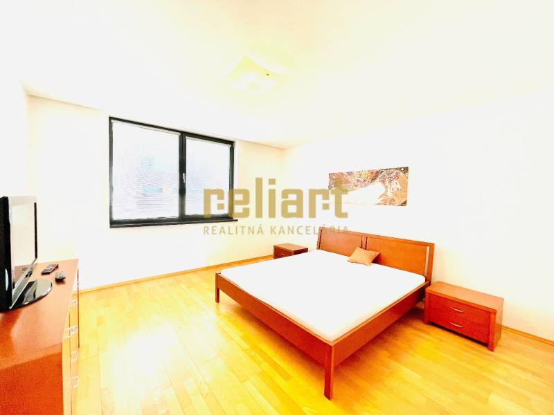 A bright bedroom with stylish furniture and a wood-patterned floor in a 4-room apartment.