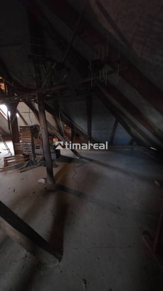 Attic space of a family house with wooden beams and stored crates.