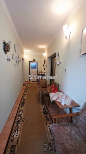 Hallway in a family house with decorative plates on the wall and a carpet.