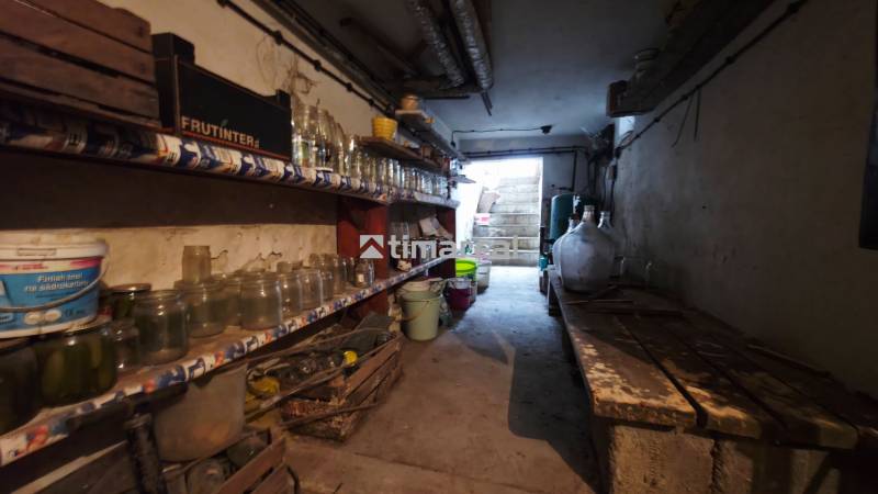 Basement of a family house with shelves full of canning jars and other equipment.