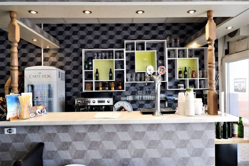A bar counter with drinks and beer taps in commercial premises.
