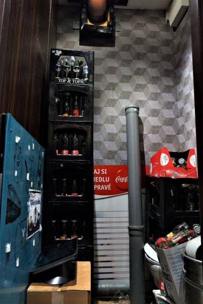 Storage space in commercial premises with bottles and pipes.