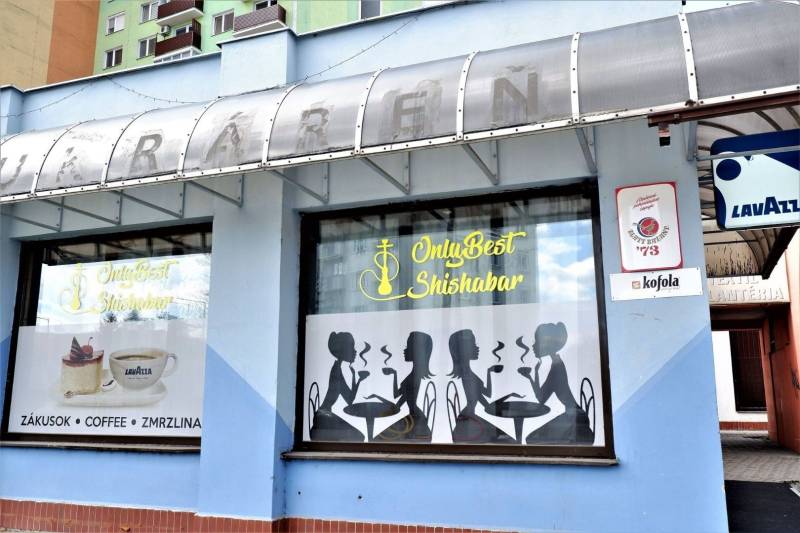 The exterior of commercial premises in Šaľa with graphic silhouettes and advertising for Lavazza coffee.