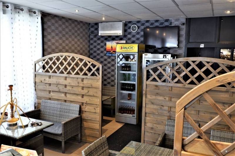 Commercial premises with rattan seating and a beverage refrigerator.