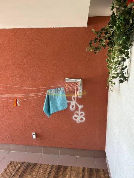 Balcony of a 4-room apartment with a colorful wall, white graphite, and wooden decor flooring.
