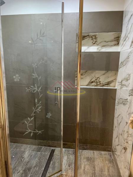 Shower enclosure with decorative glass and tiles in a 4-room apartment.