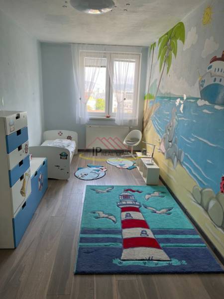 A children's room in a 4-room apartment with colorful carpets and a wall mural.