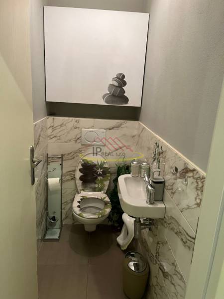 A bathroom in a 4-room apartment with marble tiles and a modern sink.