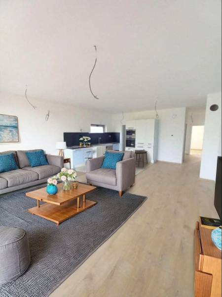 Living room in a family house with a wooden decor floor, sofa, and decorations.