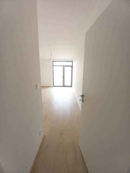 Interior of a family house with a wooden decor floor and a large window.