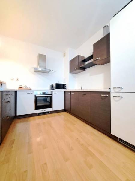 A kitchen with a wooden decor floor in a 2-room apartment.