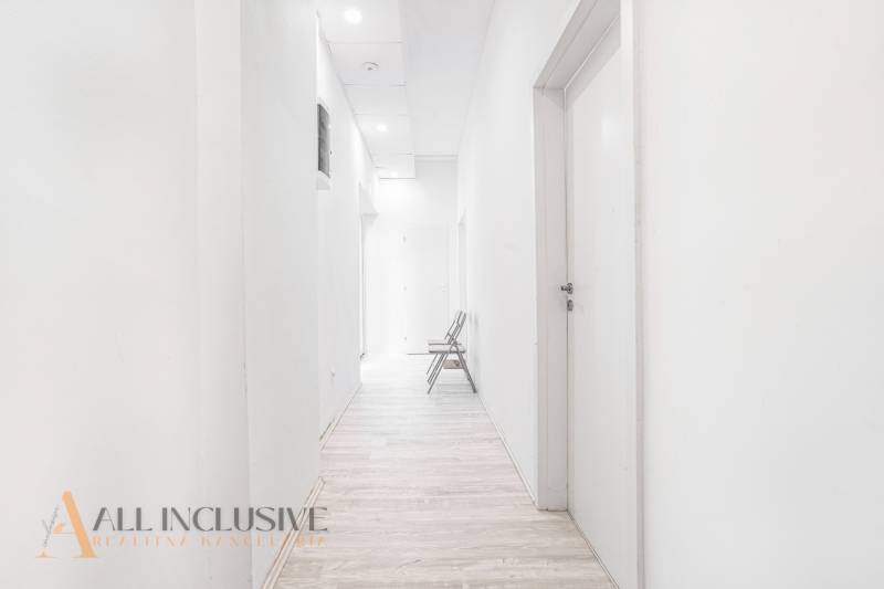 A bright hallway with a wooden floor and a chair in the office.