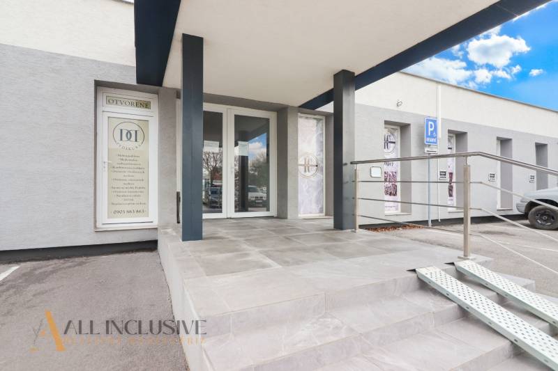 Entrance to commercial premises on Vajanského Street, with wheelchair access and a parking space.