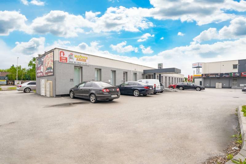 Buildings on Clementis Gardens in Galanta with parked vehicles near the offices.