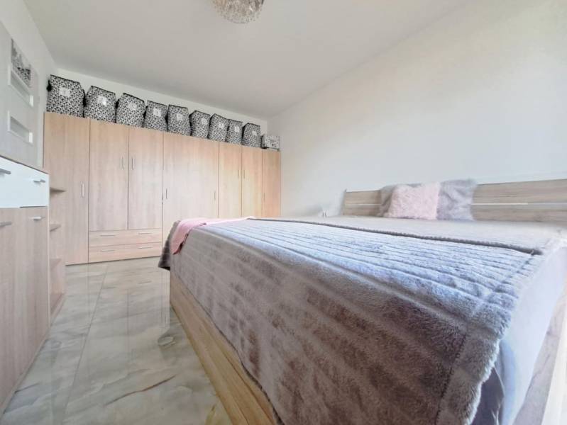 Bedroom in a family house with a double bed, wardrobe, and floor with wood decor.