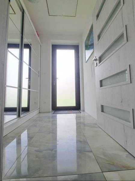 Interior of a family house with a glossy ceramic floor and glass doors.