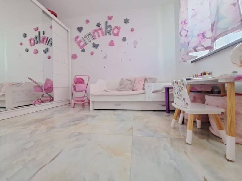 Children's room in a family house with decorations, furniture, and toys, floor with wooden decor.