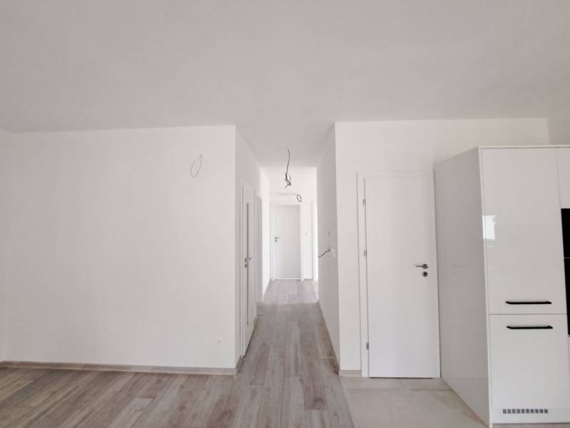 A bright interior of a family house with a wood-patterned floor and white walls.