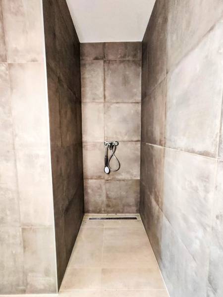 Shower enclosure in a family house with ceramic tiles.