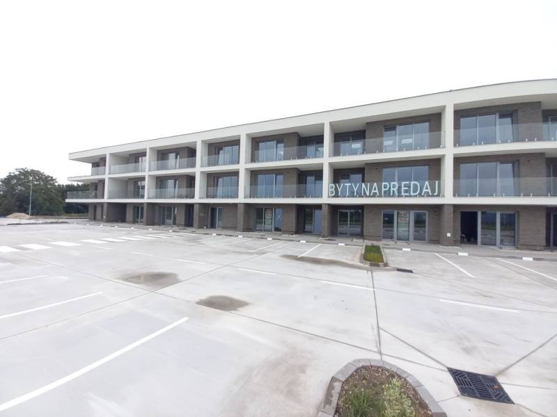 New building with balconies in Galanta for 2-room apartments, empty parking lot.