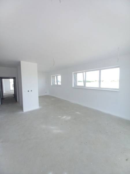 A spacious living area with large windows in a 2-room apartment.
